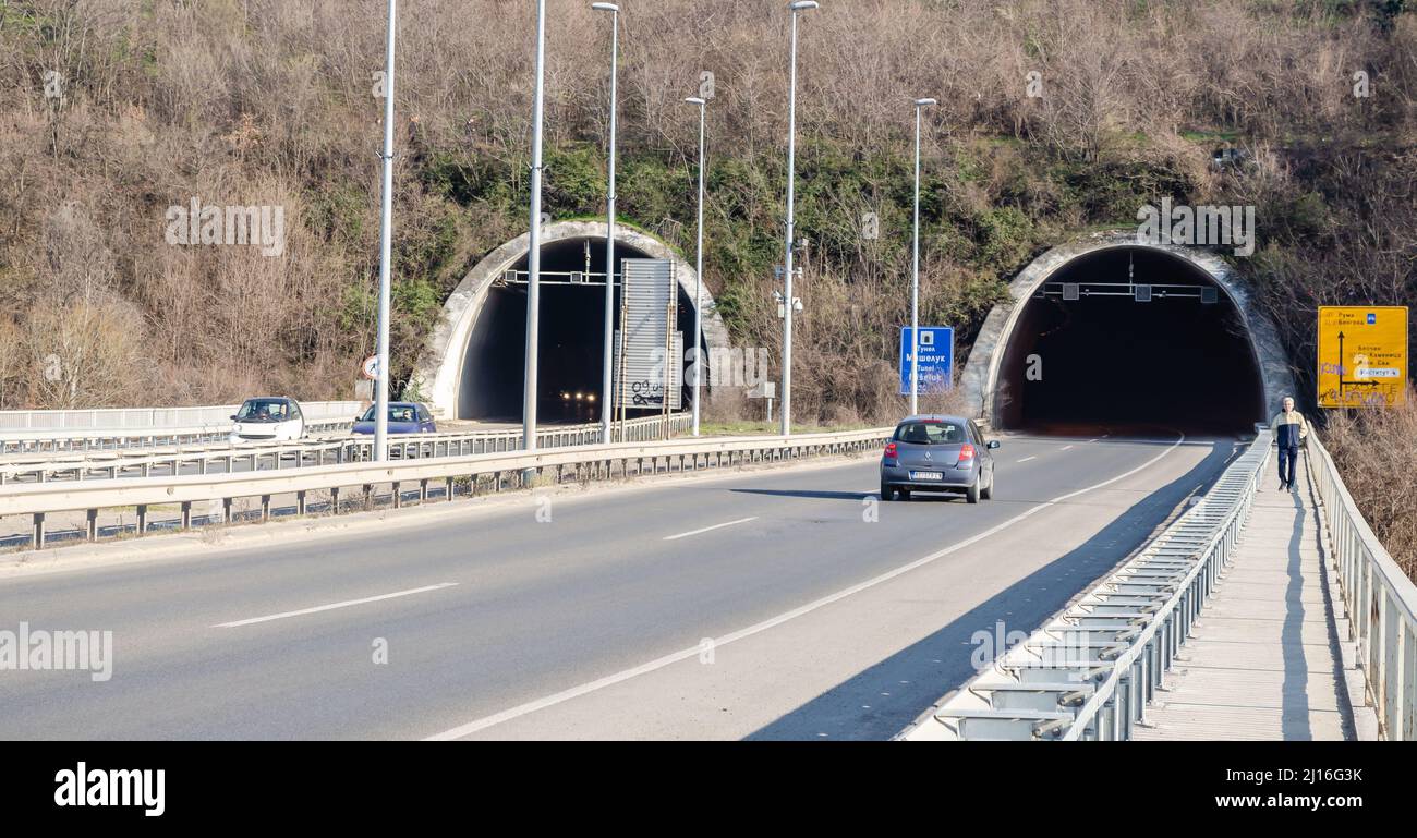 Novi Sad, Serbien. März - 16. 2021. Tunnel am Ende der Freiheitsbrücke mit Autos und Straßenschildern unter dem Teil des Fruska gora Berges. Redaktionell Stockfoto