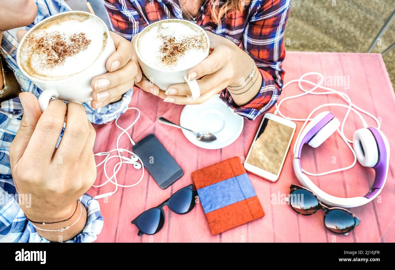 Nahaufnahme eines Freundinnen-Paares, das Cappuccino trinkt und Spaß zusammen hat - Jugendfreundschaftskonzept mit jungen Frauen, die sich unterhalten und Kaffee genießen - B Stockfoto