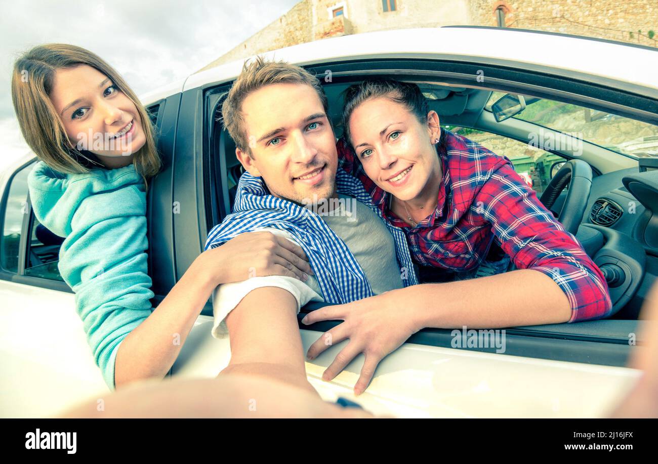 Gutaussehender Kerl, der Spaß mit Freundinnen hat - Beste Freunde, die Selfie auf Autotour machen - Glückliche Freundschaft und Fernweh-Konzept mit Menschen tr Stockfoto