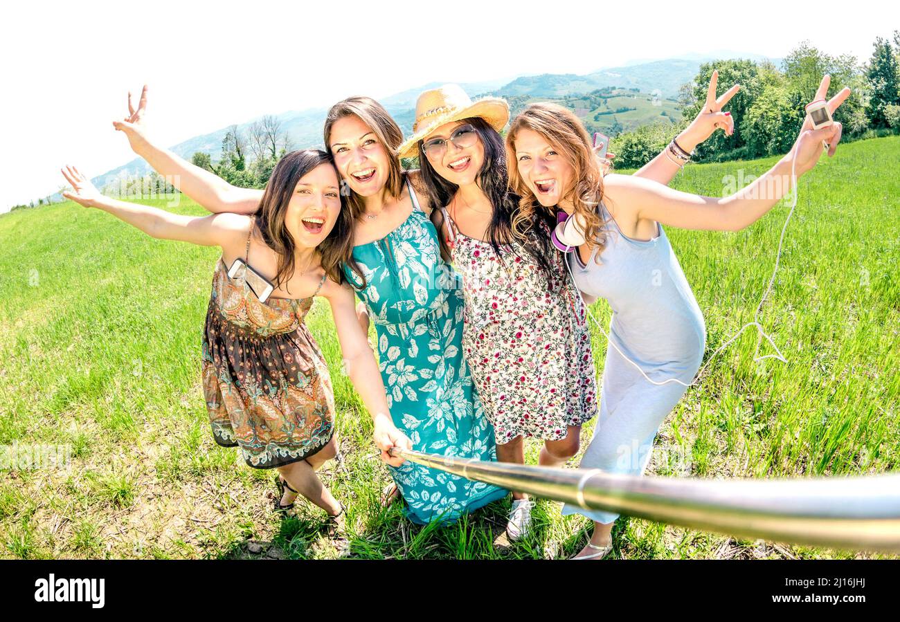 Multirassische Freundinnen, die beim Country Picknick Selfie mit Stick machen - Happy Friendship Konzept und Spaß mit jungen Menschen, die gemeinsam Spaß haben - Sunny af Stockfoto