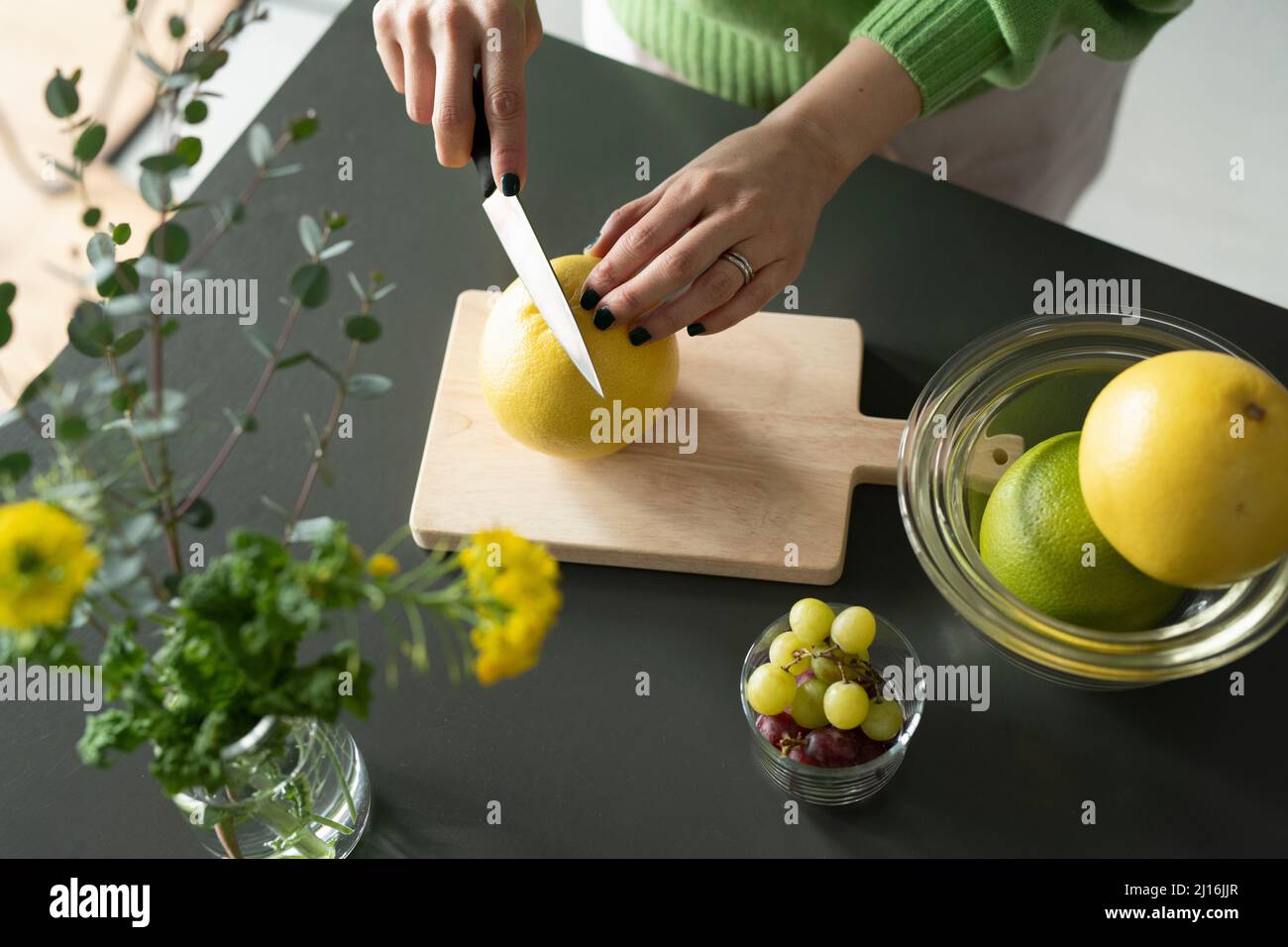 Frau Schneidet Grapefruit Stockfoto