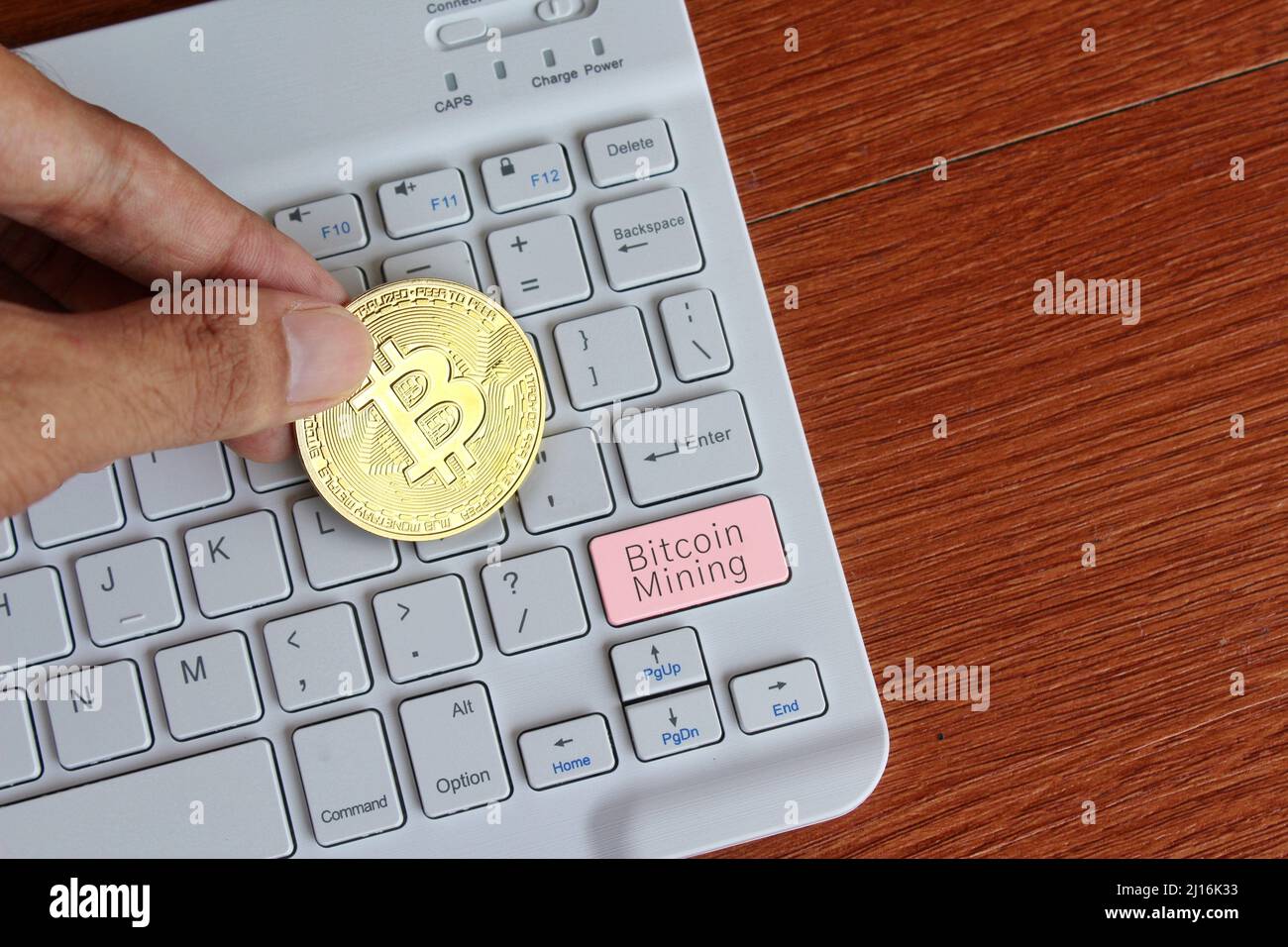 Hand halten Bitcoin und Tastatur mit Text Bitcoin Mining. Kryptowährungs-Mining-Konzept. Stockfoto