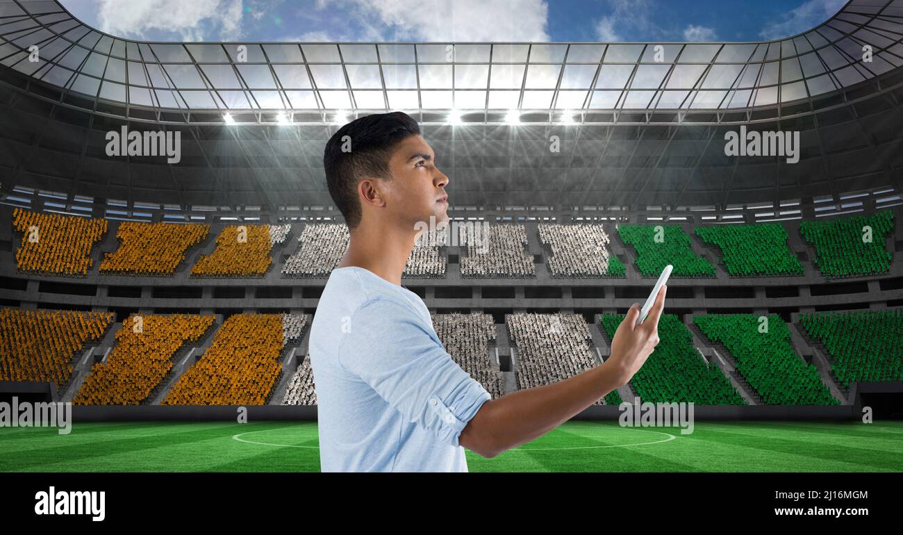 Composite-Bild des indischen Mannes mit Smartphone gegen Sportstadion Stockfoto