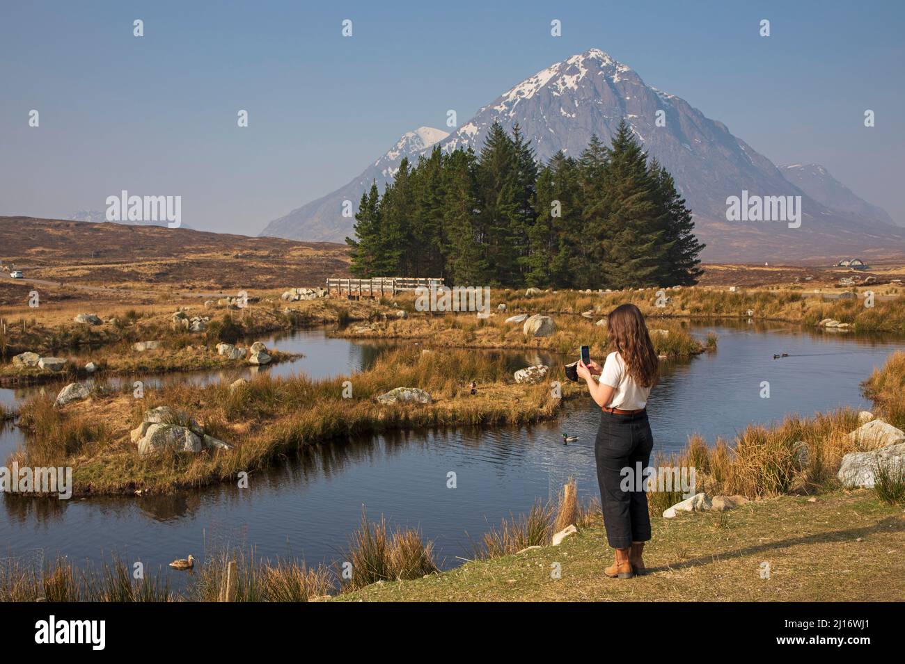 Glencoe, Lochaber, Schottland, Großbritannien. 23.. März 2022. Sehr hazig mit Sonnenschein, Temperatur von 13 Grad Celsius, um den Tag zu beginnen, steigt auf 16 Grad am Morgen. Im Bild: Dekorativer Teich im Kings House Hotel, mit Buachaille Etive Mor im Hintergrund. Kredit: Archwhite/alamy Live Nachrichten. Stockfoto