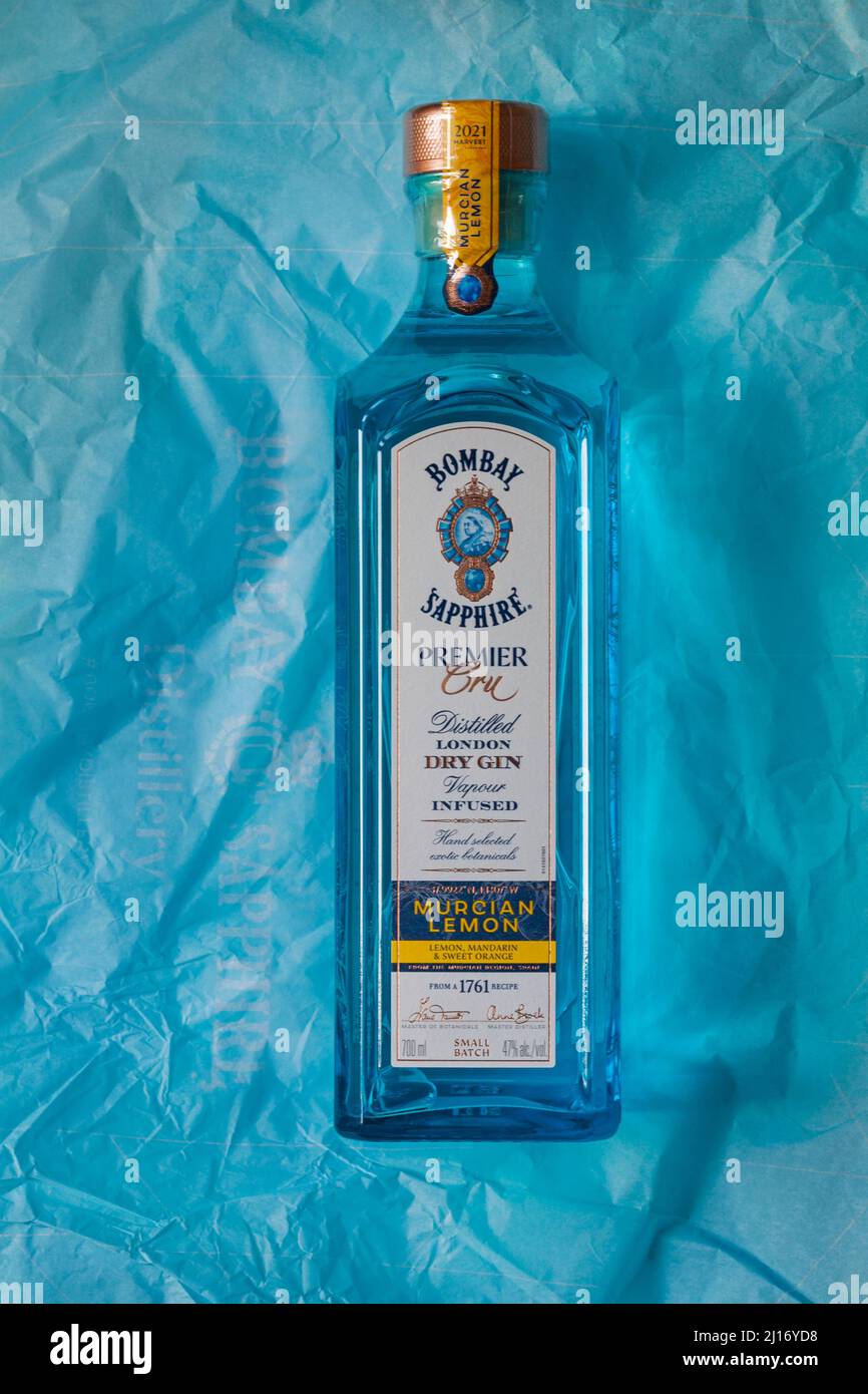 Flasche Bombay Sapphire Premier Cru destillierter London Dry Gin Vapor mit Murcian Lemon Hand ausgewählte exotische Botanicals auf blauem Seidenpapier Stockfoto