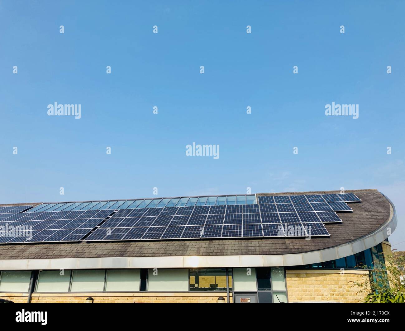 Solarmodule zur Erzeugung von Solarstrom auf dem Dach eines öffentlichen Bibliotheksgebäudes in Otley, Großbritannien. Stockfoto