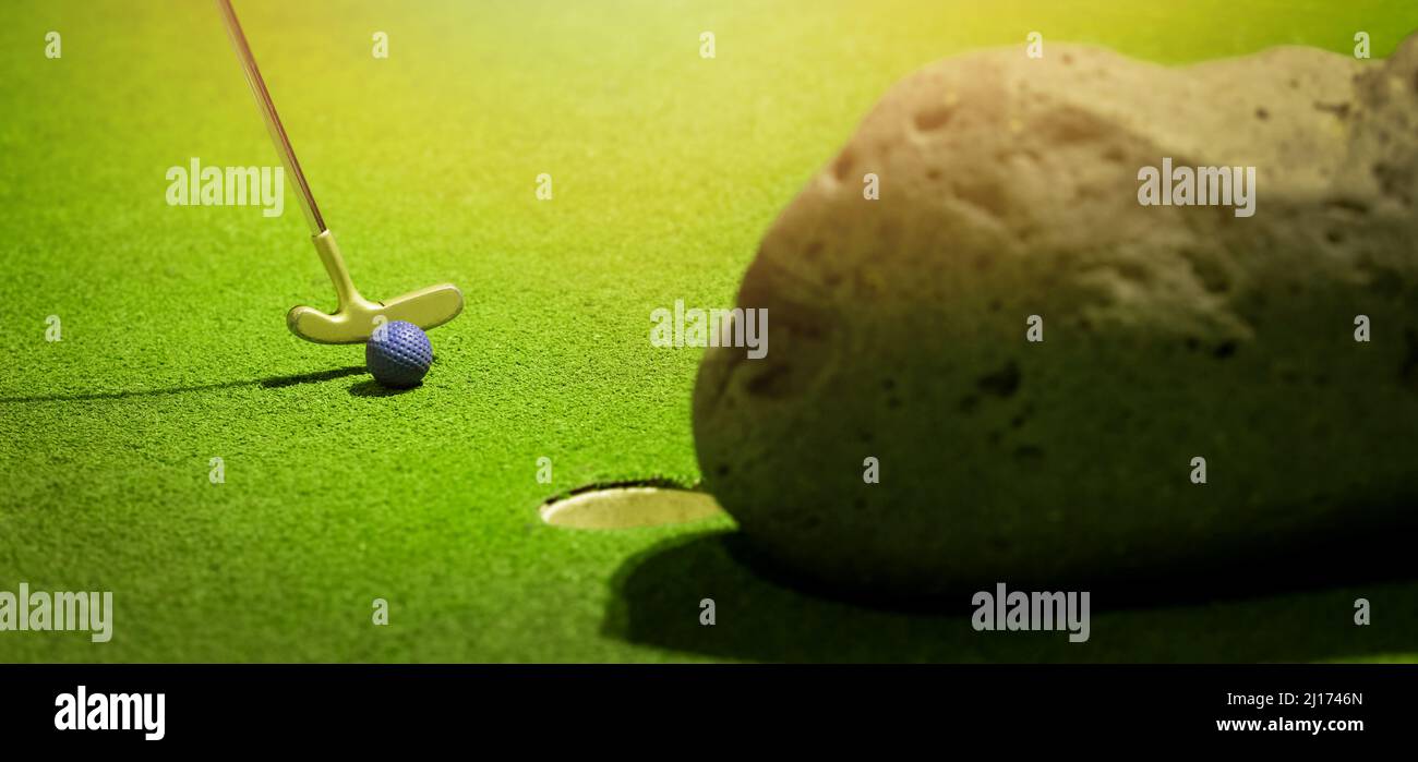 Minigolf - Putter traf den Ball auf grünem Kunstrasen. Banner mit Kopierraum Stockfoto