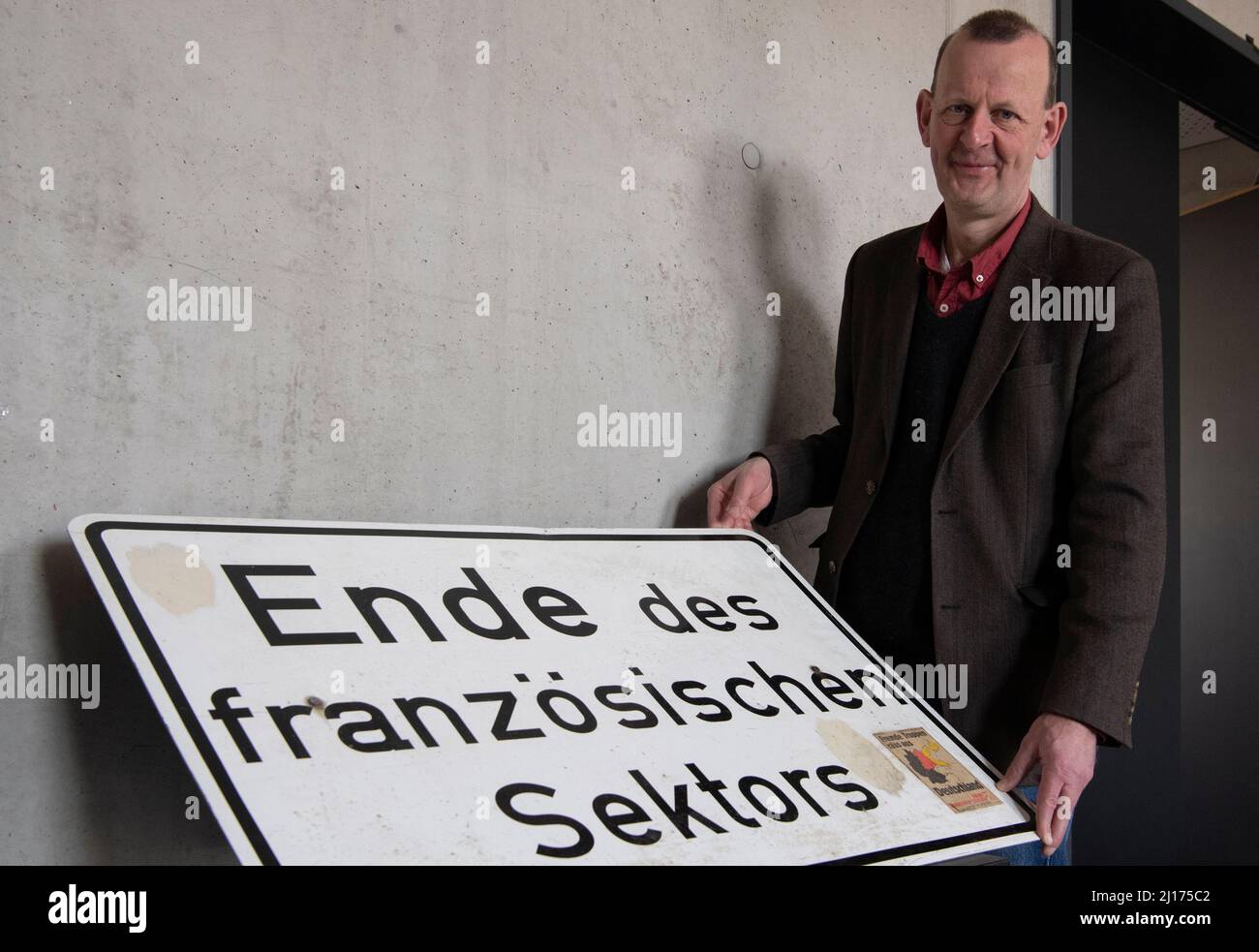 Berlin, Deutschland. 23. März 2022. Dr. Axel Klausmeier, Direktor der Stiftung Berliner Mauer, hält während eines Pressegesprächs ein Sektorschild aus dem ehemaligen französischen Sektor in Wedding. Die Stiftung hat ihre Bestände aus der Zeit der Teilung Berlins nun online gestellt. Interessierte können die Datenbank frei recherchieren, sich über den Kontext jedes der mehr als 10.000 Objekte informieren und eigene Kommentare abgeben. Quelle: Paul Zinken/dpa/Alamy Live News Stockfoto