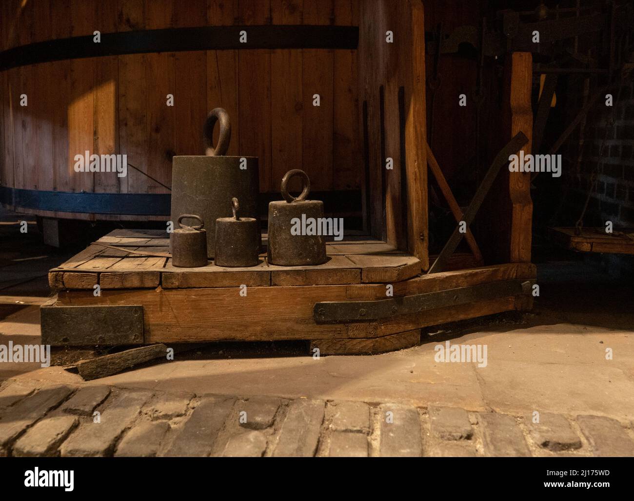 Alte Metallgewichte auf einer antiken Holzskala Stockfoto