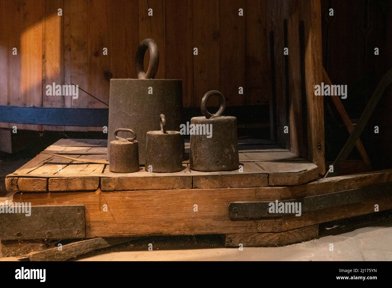 Alte Metallgewichte auf einer antiken Holzskala Stockfoto