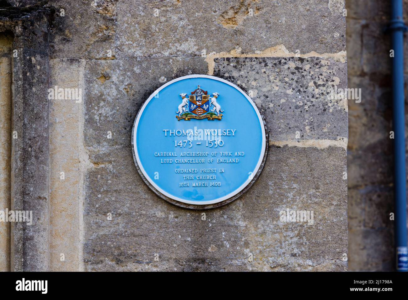 Blaue Gedenktafel an der Wand der St. Peter's Church aus dem 15.. Jahrhundert zur Feier der Weihe von Thomas Wolsey im Jahr 1498, High Street, Marlborough, Wiltshire Stockfoto