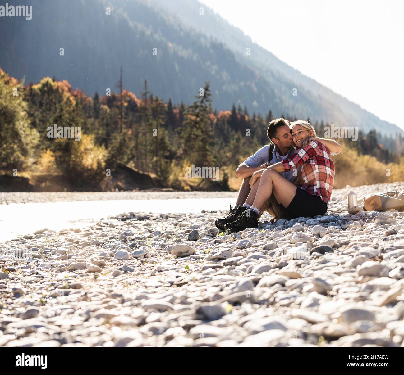 Österreich, Alpen, zärtlich Paar auf einer Wanderung in einer Pause an einem Bach Stockfoto