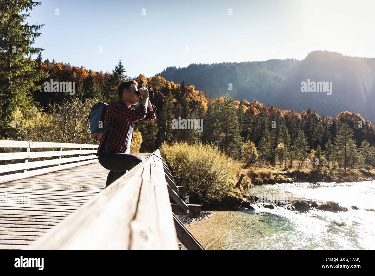 Österreich, Alpen, Mann auf einer Wanderung auf der Suche durchs Fernglas Stockfoto