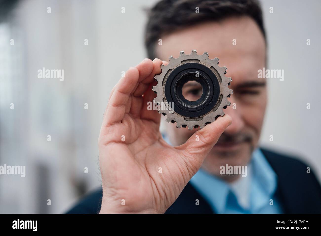 Geschäftsmann, der durch ein Objekt schaut Stockfoto