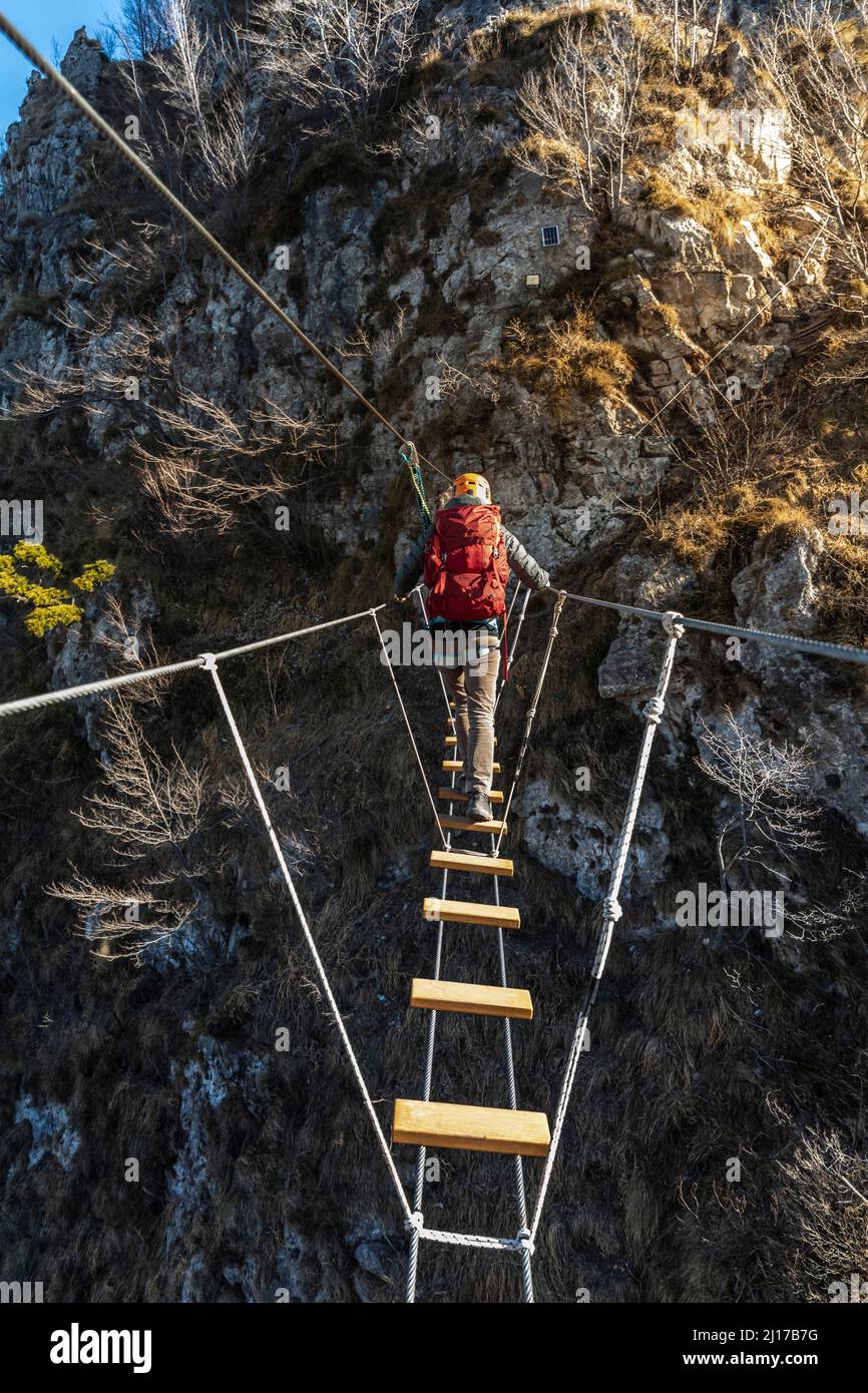 Abenteuerlicher Backpacker, der die tibetische Brücke überquert, Orobie alps, Bergamo, Italien Stockfoto