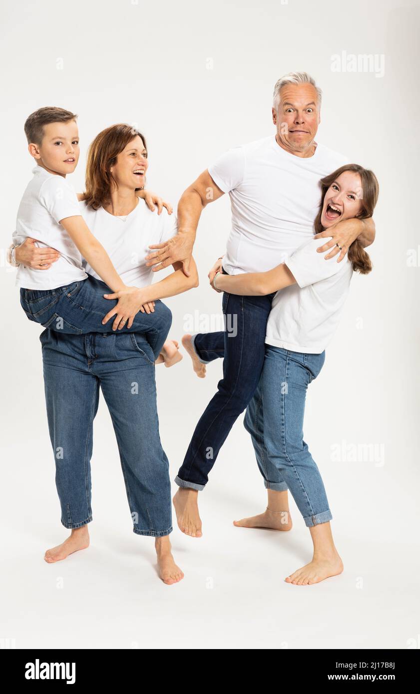 Mutter trägt Sohn und Tochter, die Vater im Studio hält Stockfoto