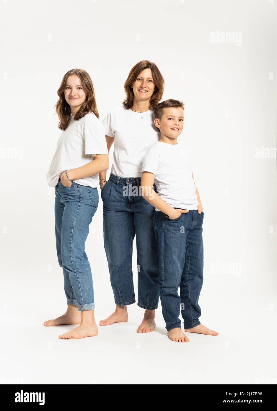 Mutter mit Tochter und Sohn stehen mit Händen in den Taschen Stockfoto