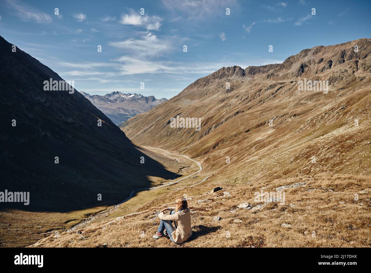 Tourist sitzt auf Land durch Berg im Urlaub, Timmelsjoch Pass, Otztaler Alpen, Österreich Stockfoto