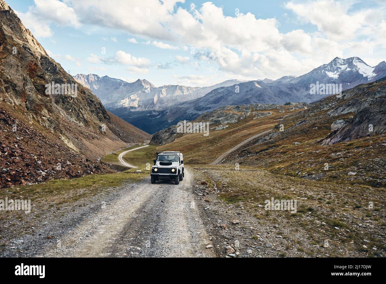 Geländewagen auf Schotterpiste durch Berge, Schnalstal, Südtirol, Italien Stockfoto