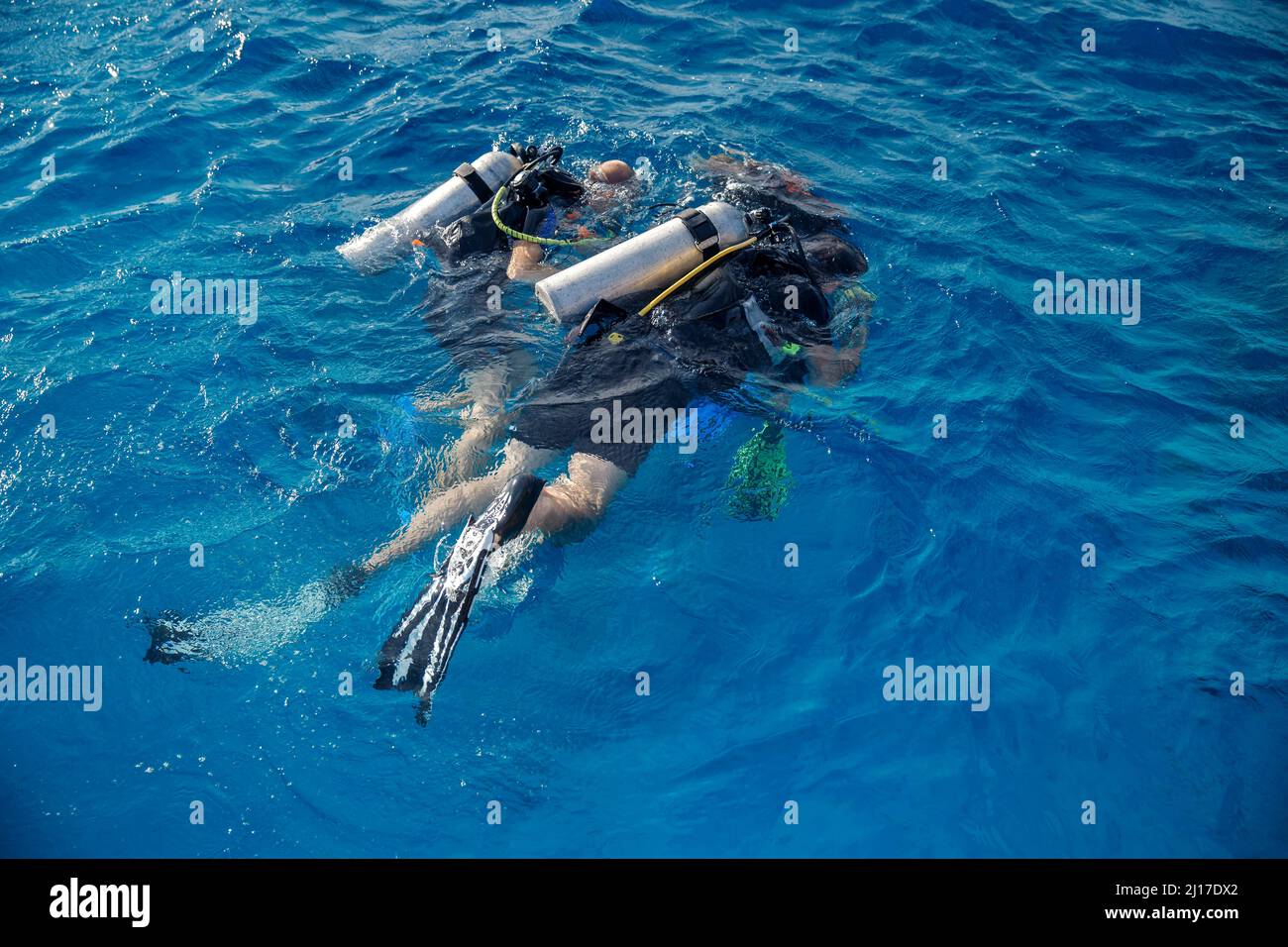 Tauchausbildung, Instruktor weist Touristen an, unter Wasser mit Tauchen im Meer zu tauchen, Draufsicht. Stockfoto