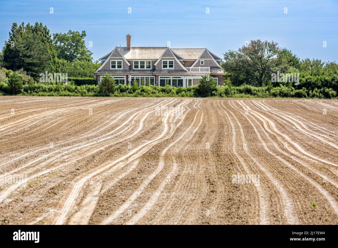 Landschaft bestehend aus einem frisch gepflügten Feld und einem teuren Zuhause Stockfoto