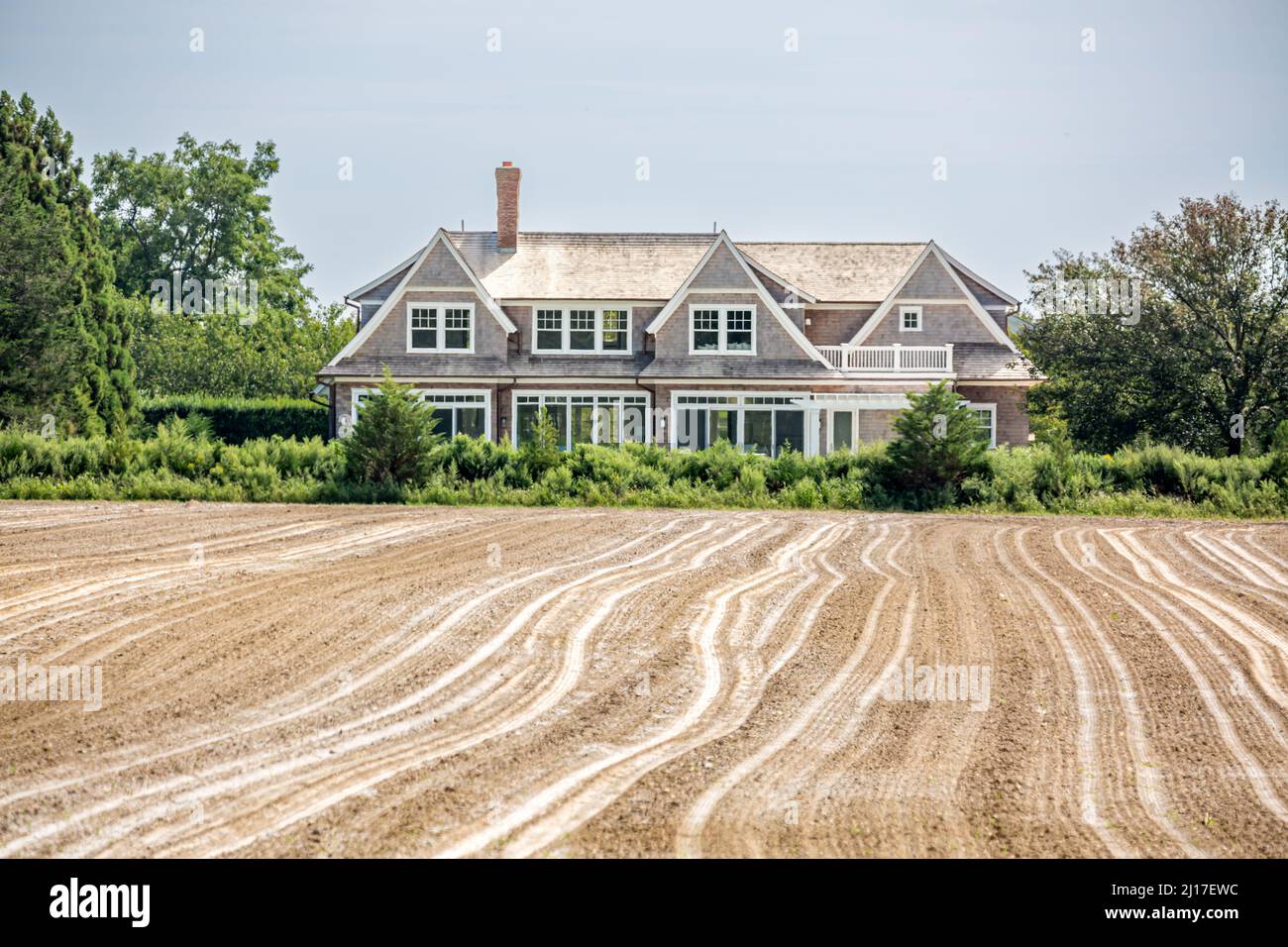 Landschaft bestehend aus einem frisch gepflügten Feld und einem teuren Zuhause Stockfoto