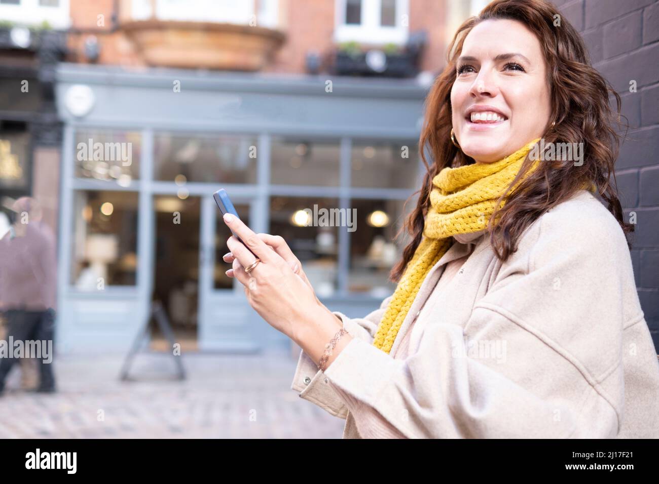 Glückliche junge Frau mit Mobiltelefon Stockfoto