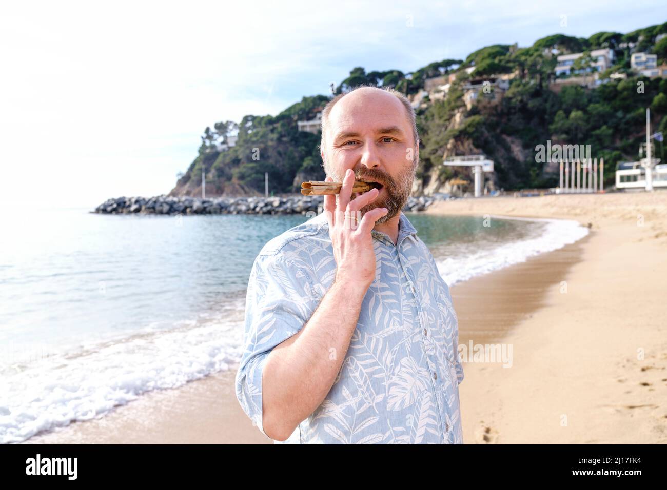 Mann raucht Zigarre am Strand Stockfoto