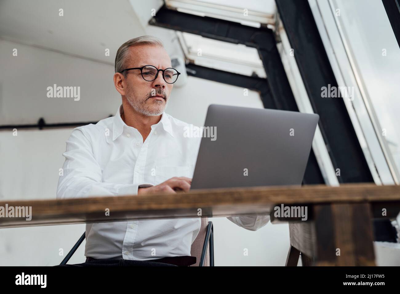 Geschäftsmann, der im Startup-Büro am Laptop arbeitet Stockfoto