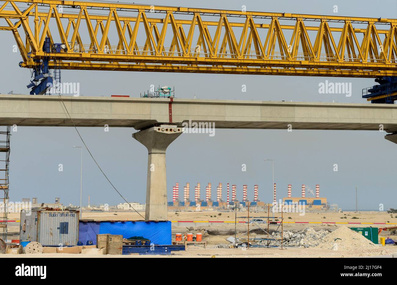 QATAR, Doha, Qatar Rail City Train Bridge Construction und Ras Laffan C, ein Wasser- und Gaskraftwerk (IWPP) mit einer kombinierten Leistung von 2.730 MW Strom und 63 Millionen imperialen Gallonen entsalztem Wasser pro Tag (286,4 Millionen Liter pro Tag). Das Projekt kann rund 30 Prozent des Strombedarfs von Katar und 20 Prozent des Trinkwasserbedarfs pro Tag decken. Katar ist einer der größten Produzenten und Exporteur von Flüssiggas / KATAR, Doha, Al Wakra, Bau einer neuen S-Bahn, Hintergrund Ras Laffan C IWPP Gaskraftwerk und Meerwasserentsalzungsanlage, das Emirat Katar ist einer der Stockfoto