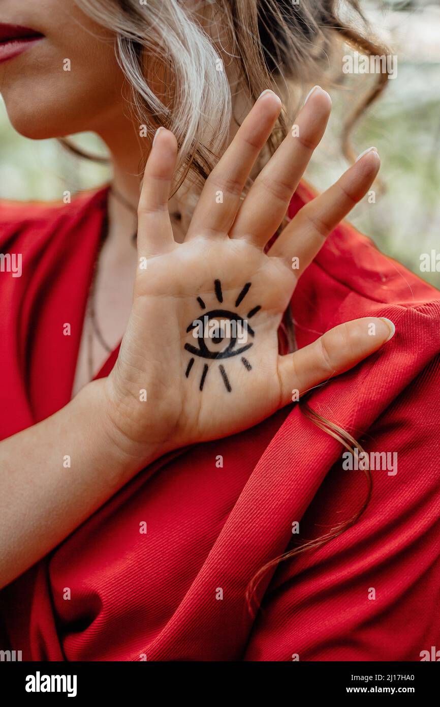 Junge Frau mit Augenschild-Tätowierung auf der Hand Stockfoto