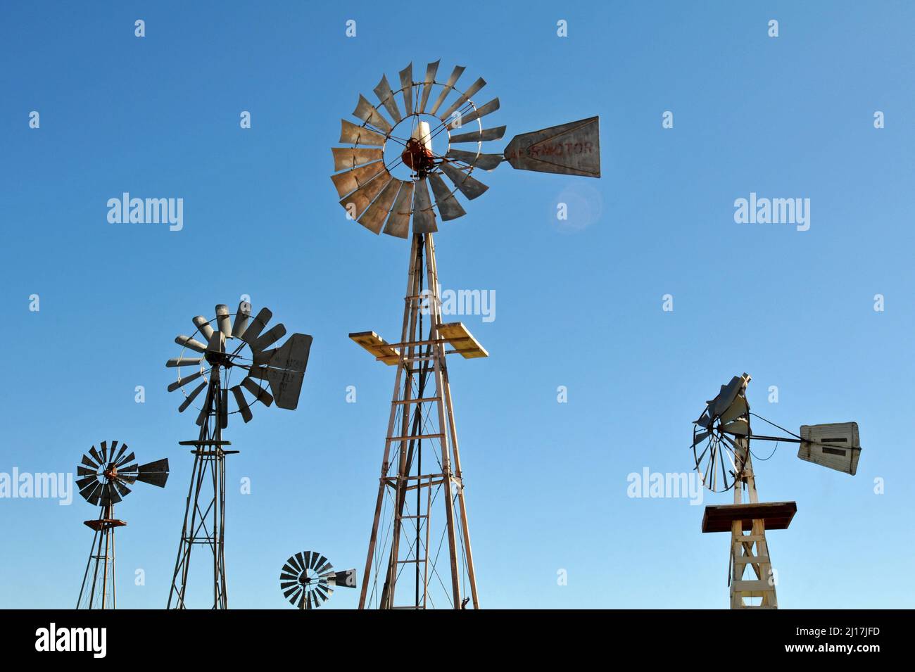 Eine Sammlung historischer Metallwindmühlen steht vor einem blauen Himmel im Farm and Ranch Museum, das Teil eines Museumskomplexes in Elk City, Oklahoma, ist. Stockfoto