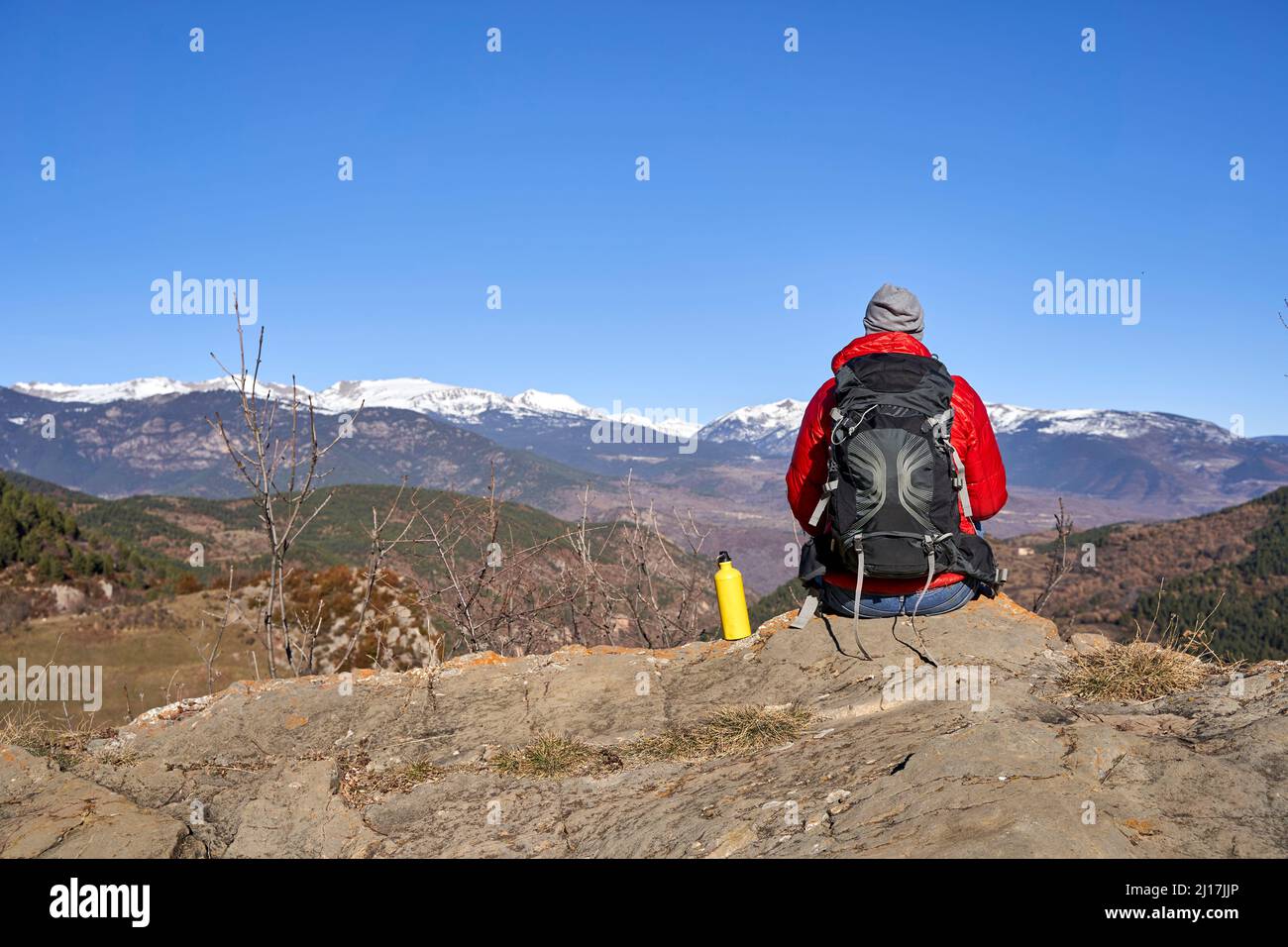 Wanderer im Rucksack sitzen an der Wasserflasche auf Felsen Stockfoto