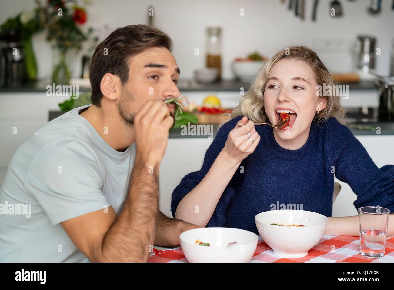 Junge Frau und Mann essen am Tisch Stockfoto