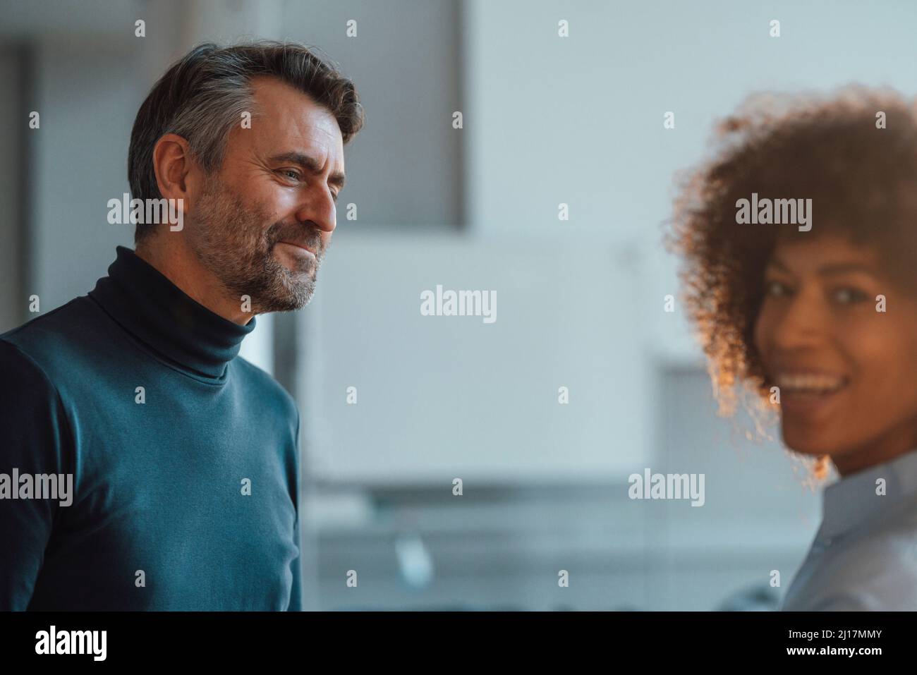Ein Arbeiter, der einen Kollegen im Büro ansieht Stockfoto