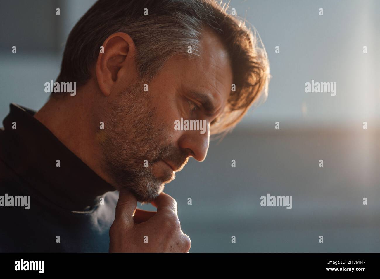 Arbeiter mit der Hand am Kinn am Arbeitsplatz Stockfoto