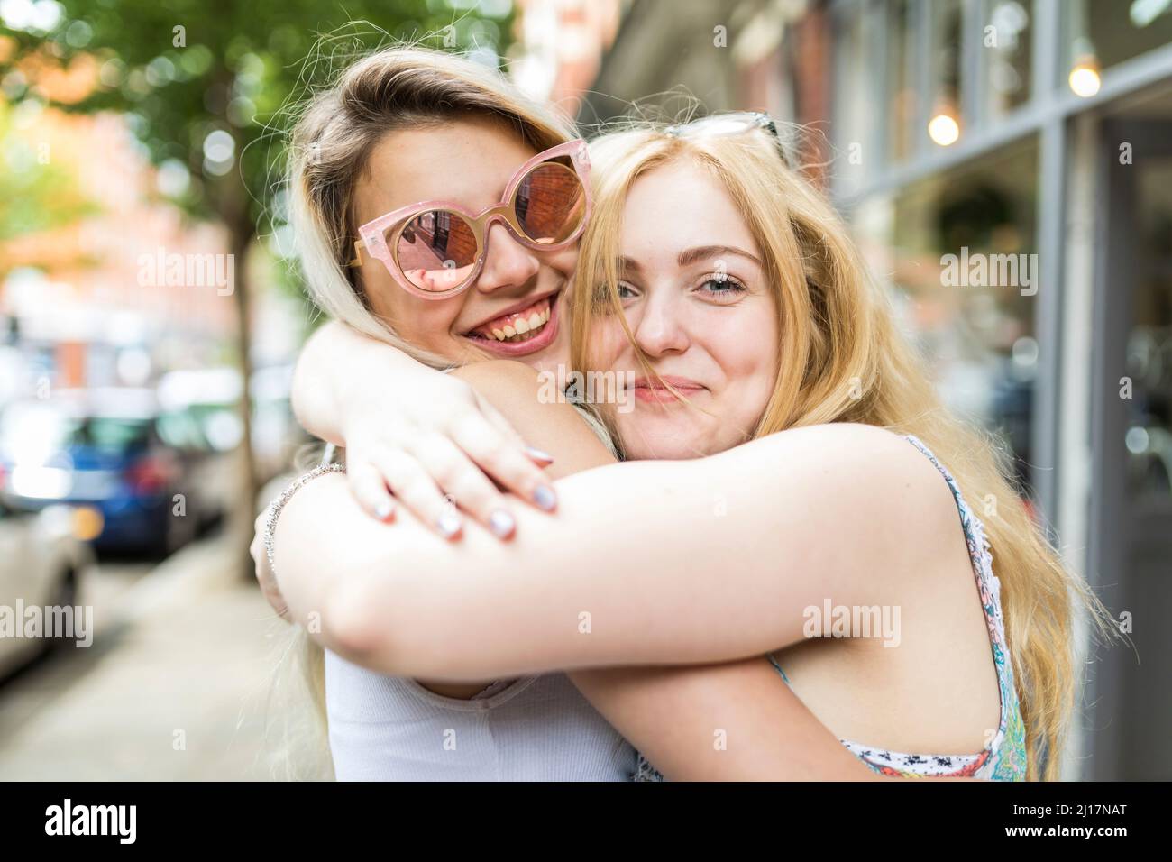 Glückliche Teenager-Mädchen mit blonden Haaren umarmen sich gegenseitig Stockfoto