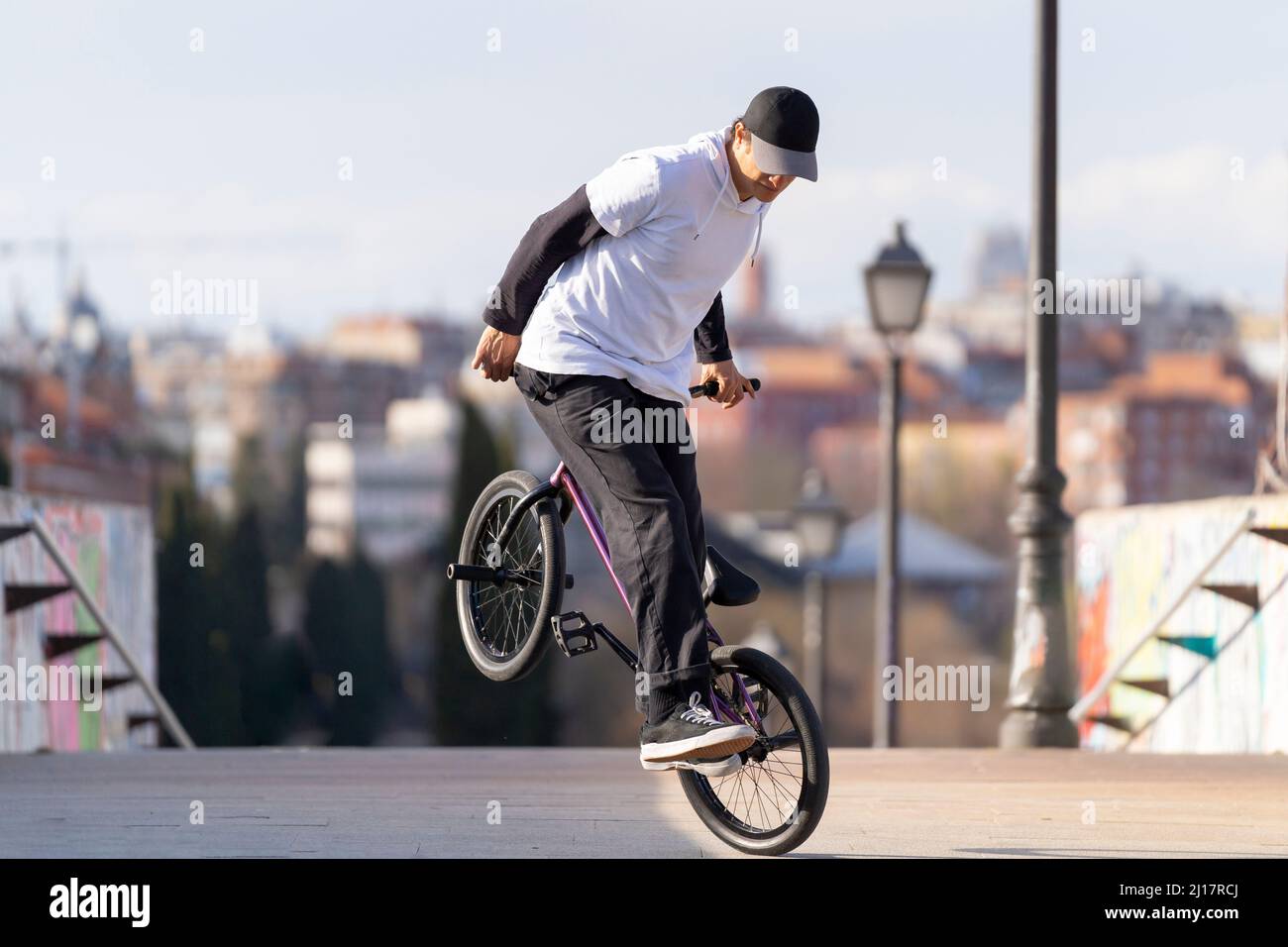 Determinanter Mann, der in der Stadt einen Trick auf dem Fahrrad macht Stockfoto