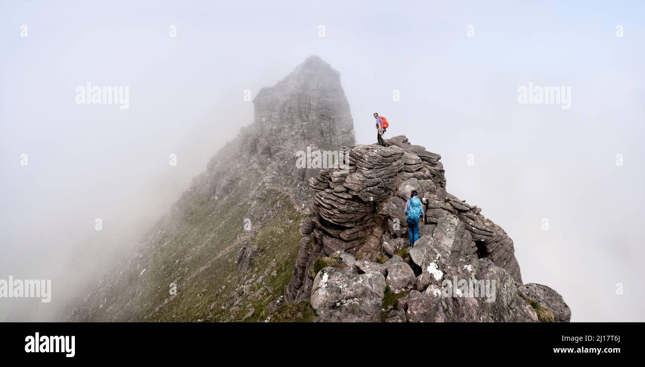 Mann und Frau gehen auf einem felsigen Berg Stockfoto