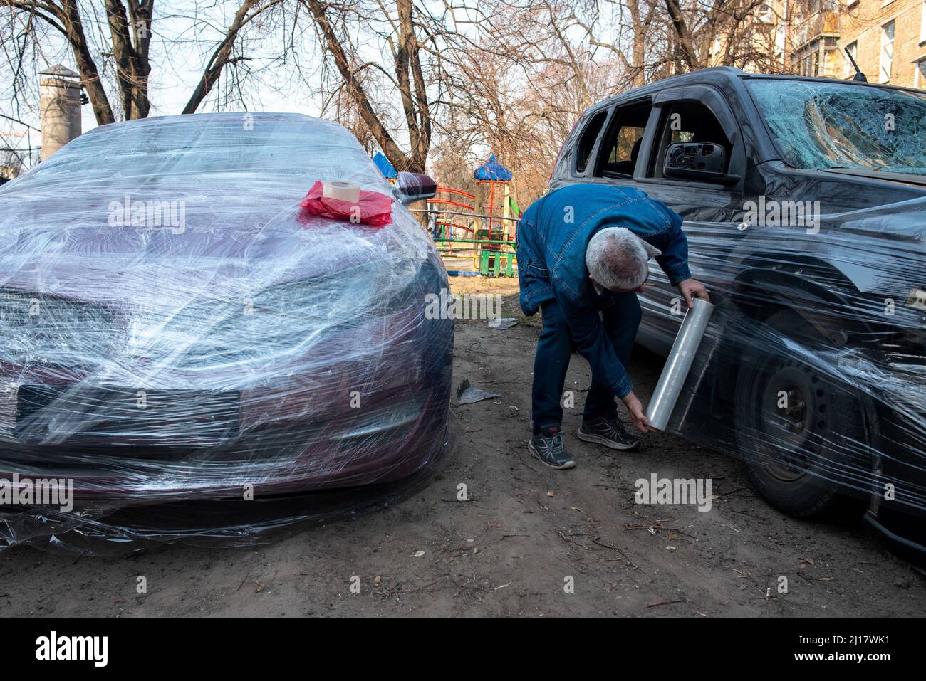 Kiew, Maine, Ukraine. 23. März 2022. Ein Bewohner umhüllte sein Auto mit Plastik, um Schäden durch Schrapnel in Kiew zu vermeiden. (Bild: © Seth Sidney Berry/ZUMA Press Wire) Bild: ZUMA Press, Inc./Alamy Live News Stockfoto