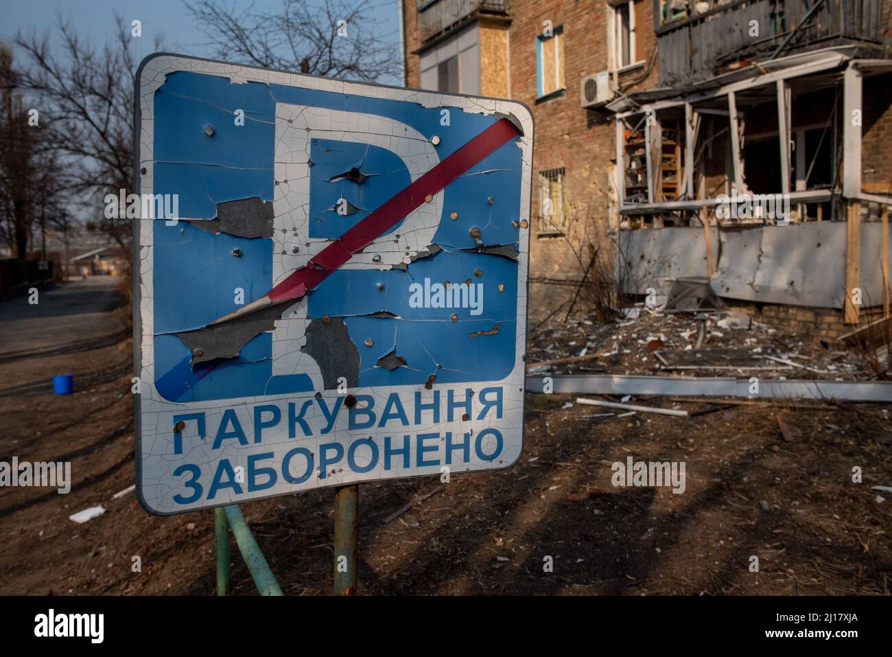 Kiew, Maine, Ukraine. 23. März 2022. Ein Schild und ein Wohngebäude, das durch einen russischen Luftangriff in Kiew durch Schrapnel beschädigt wurde. (Bild: © Seth Sidney Berry/ZUMA Press Wire) Bild: ZUMA Press, Inc./Alamy Live News Stockfoto