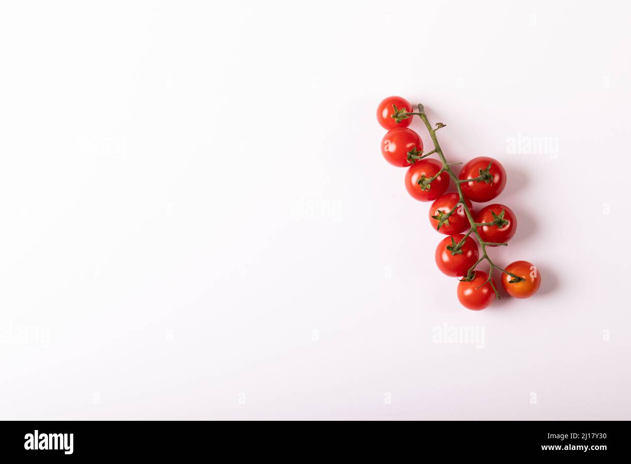 Overhead-Ansicht von frischen roten Kirschtomaten Zweig durch Kopierer Platz auf weißem Hintergrund Stockfoto