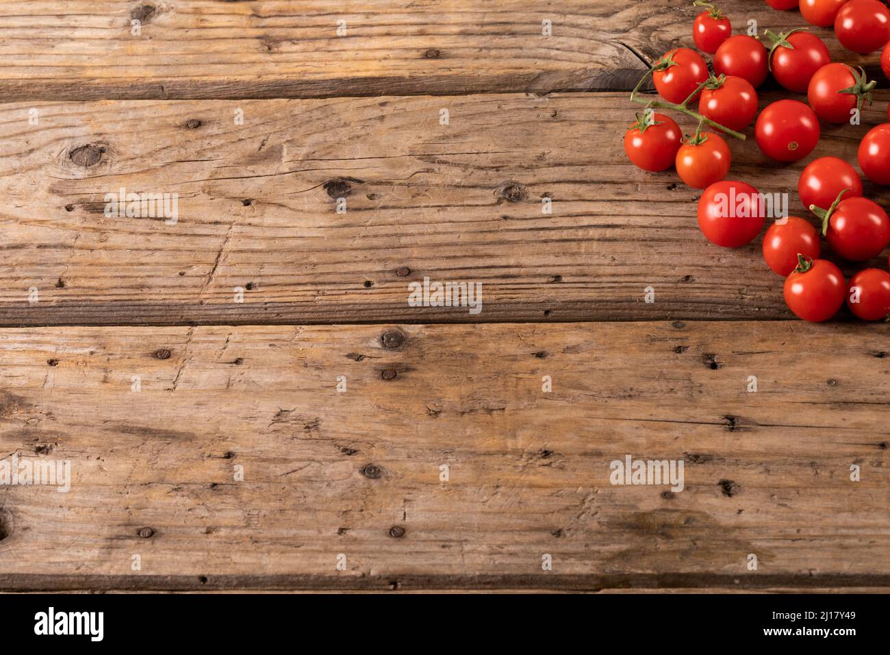 Blick von oben auf frische rote Kirschtomaten auf dem braunen Holztisch Stockfoto