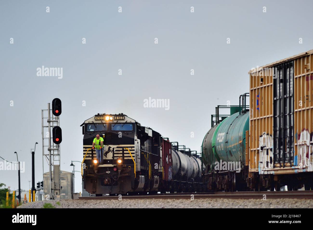 BENSENVILLE, Illinois, USA. Ein Arbeiter fährt vorne, vor einer Lokomotive der Norfolk Southern Railway, die einen Güterzug der Canadian Pacific Railway hinführt Stockfoto