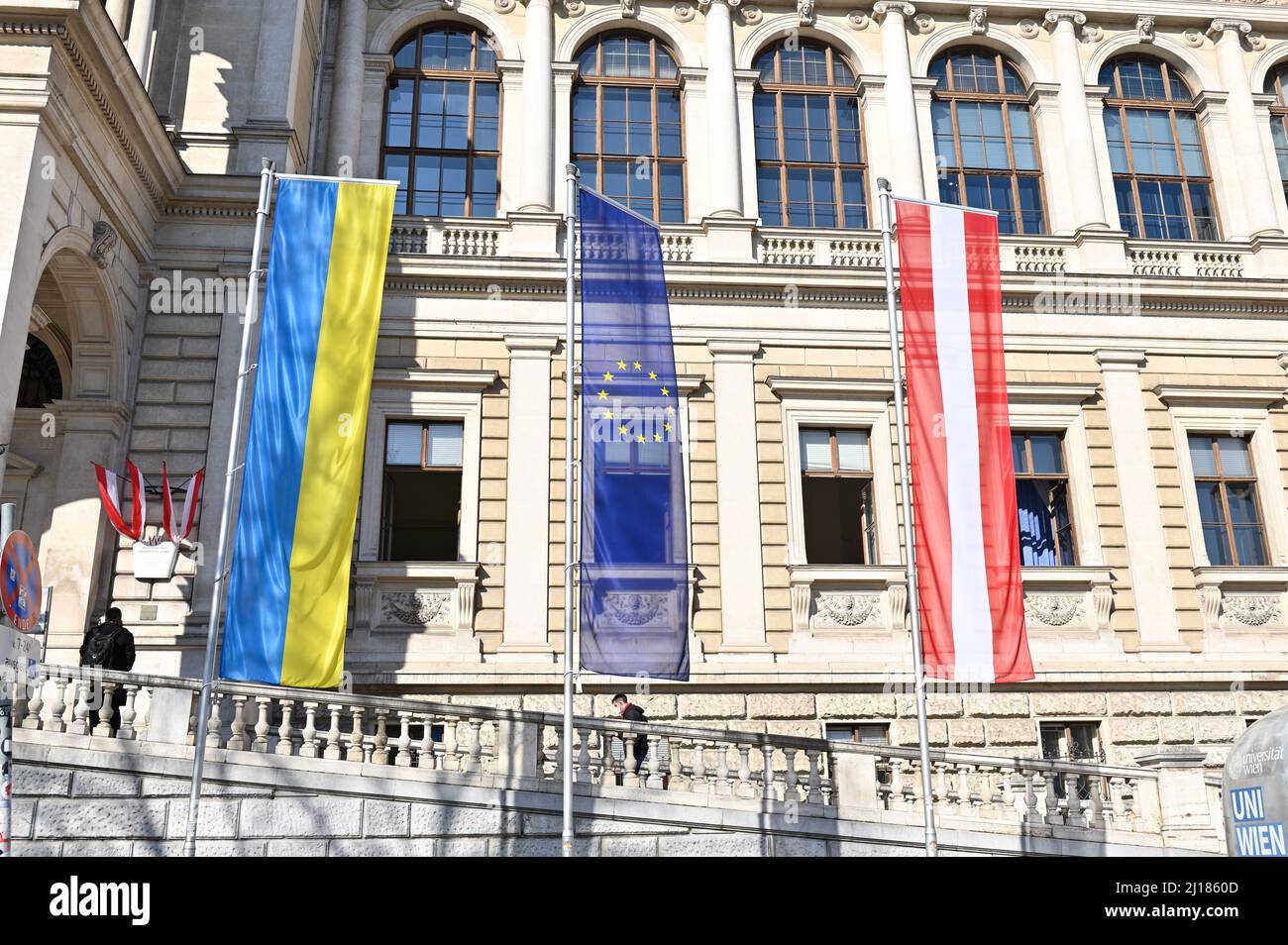 Wien, Österreich. 23. März 2022. Die ukrainische, europäische und österreichische Flagge vor der Universität Wien Stockfoto