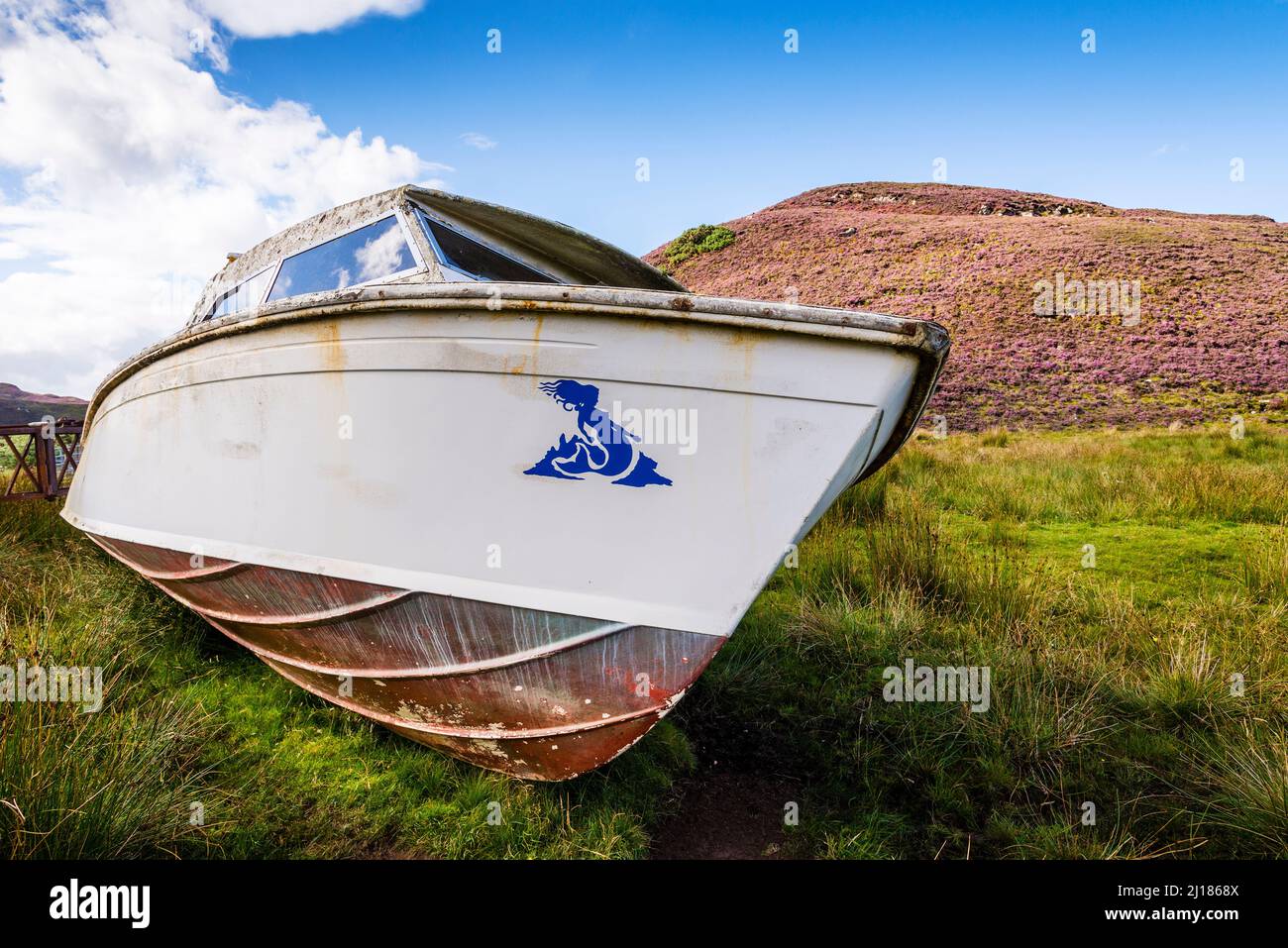 Die Sonne scheint auf einem alten Boot, das verlassen auf dem Land in der Nähe von Skerray in Schottland liegt. Stockfoto