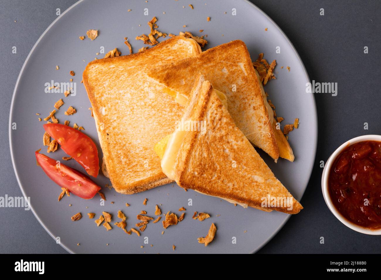 Blick von oben auf das Frischkäse-Toast-Sandwich mit Tomatenscheiben und Dip Stockfoto