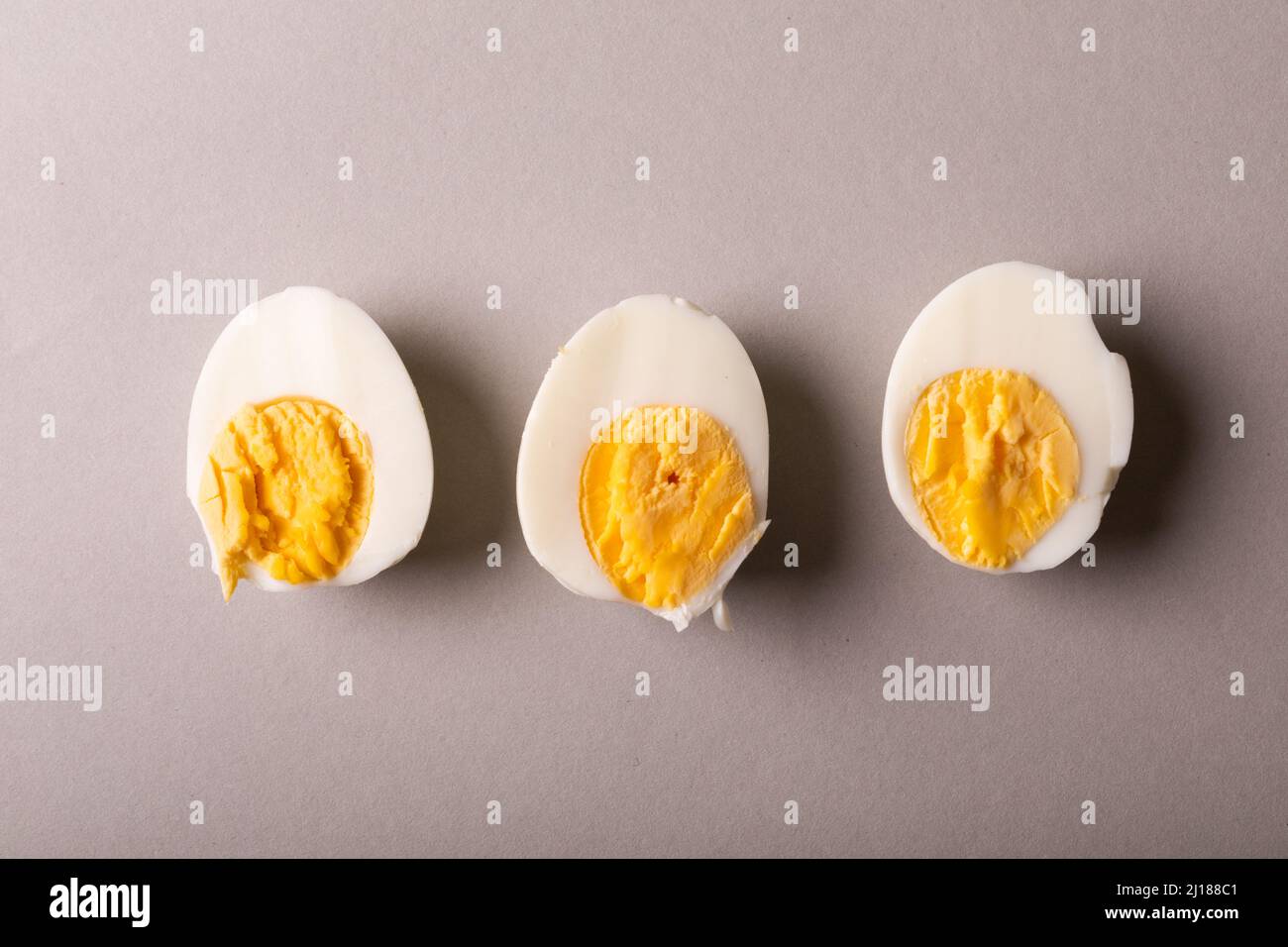 Ansicht von oben auf frisch gekochte weiße Eierhälften vor grauem Hintergrund mit Kopierraum Stockfoto