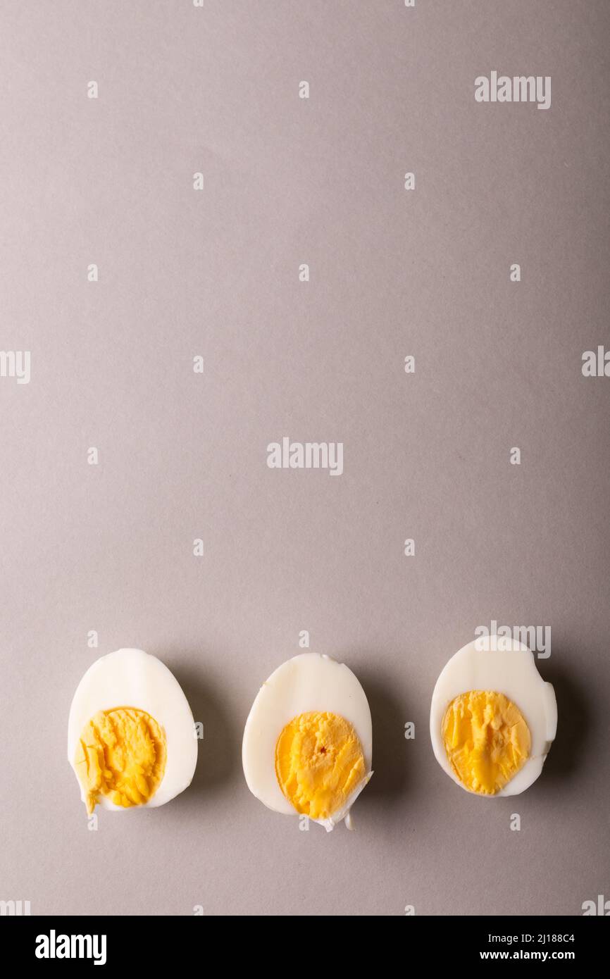 Overhead-Ansicht des Kopierraums mit frisch gekochten weißen Eierhälften vor grauem Hintergrund Stockfoto