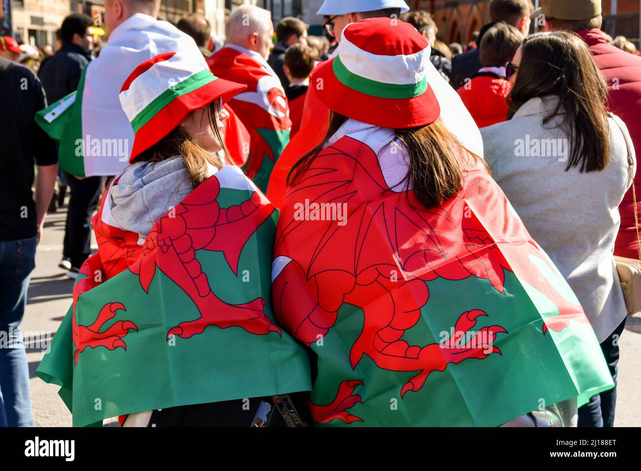 Cardiff, Wales - 2022. März: Rugby-Fans tragen am Spieltag im Stadtzentrum von Cardiff walisische Flaggen um die Schultern Stockfoto